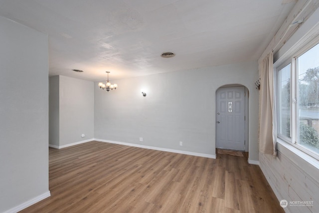 unfurnished room featuring light hardwood / wood-style floors and an inviting chandelier