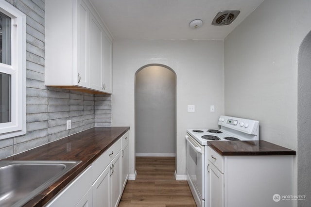 kitchen featuring white cabinetry, sink, dark wood-type flooring, white range with electric stovetop, and decorative backsplash