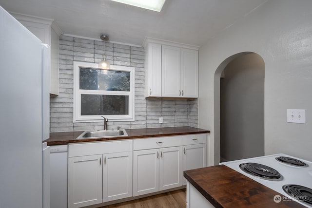 kitchen featuring butcher block countertops, dishwasher, sink, and white cabinets