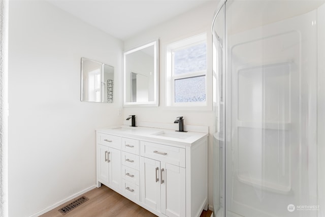 bathroom featuring hardwood / wood-style floors, vanity, and an enclosed shower