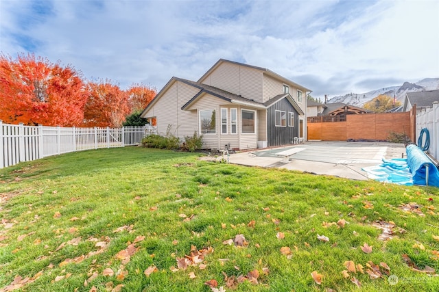 back of house featuring a lawn and a patio