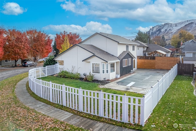 view of side of property with a mountain view and a yard