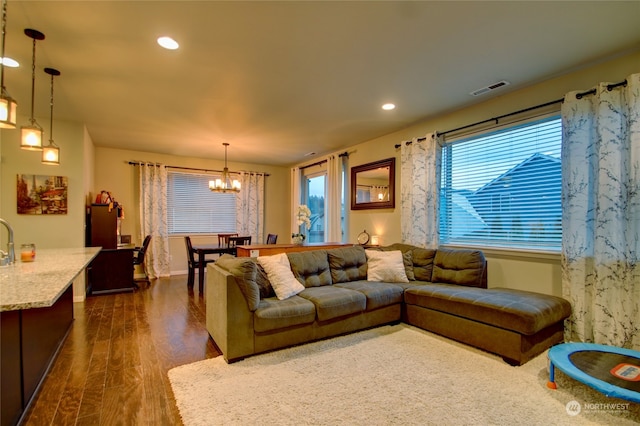 living room with a chandelier and dark hardwood / wood-style floors