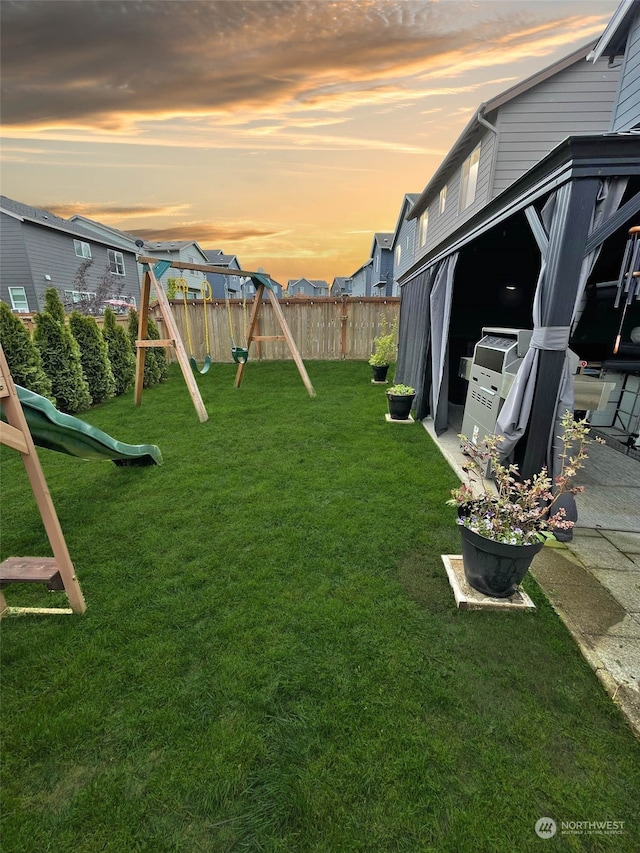 yard at dusk featuring a playground