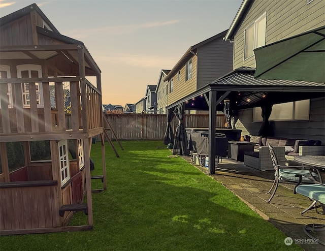 yard at dusk with a gazebo and a patio