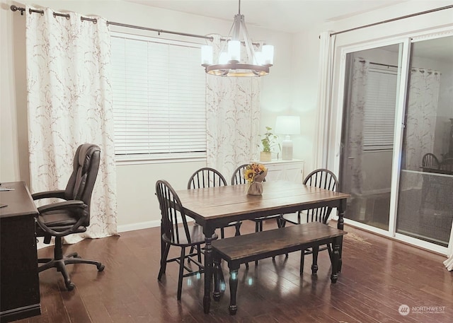 dining room with dark hardwood / wood-style flooring and a chandelier