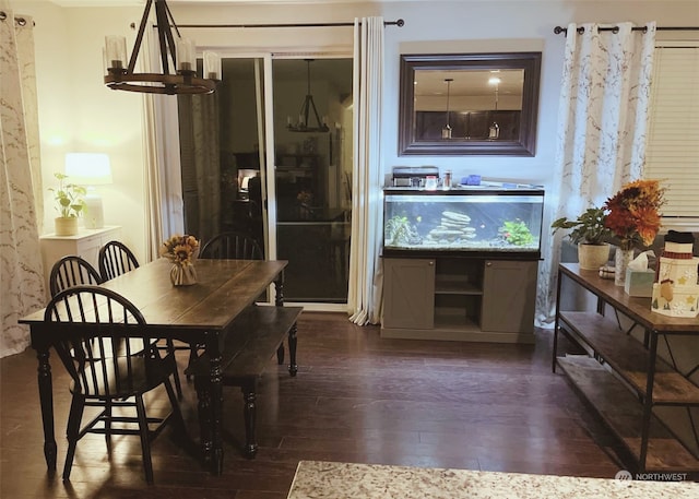 dining space with dark wood-type flooring and an inviting chandelier