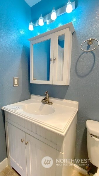 bathroom with tile patterned flooring, vanity, and toilet