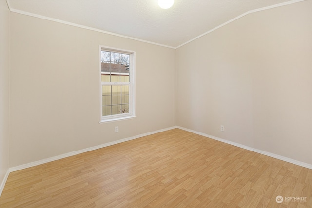 unfurnished room featuring lofted ceiling, light wood-type flooring, and crown molding