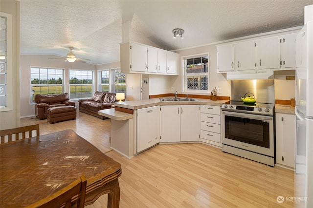 kitchen featuring sink, kitchen peninsula, white appliances, lofted ceiling, and light wood-type flooring