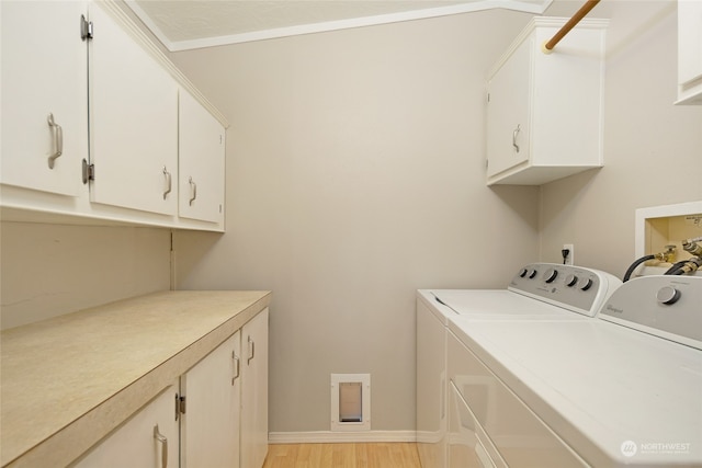 laundry room with separate washer and dryer, crown molding, cabinets, and light wood-type flooring