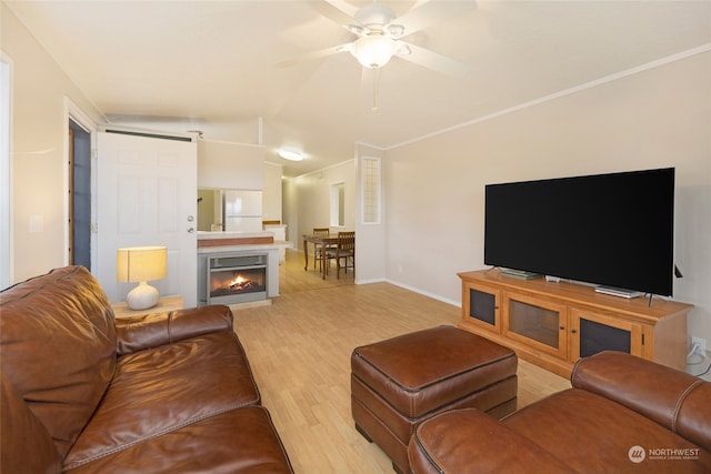 living room with ceiling fan, light hardwood / wood-style flooring, and crown molding