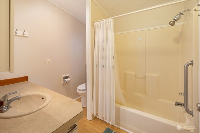 full bathroom featuring hardwood / wood-style floors, vanity, shower / tub combo, and toilet