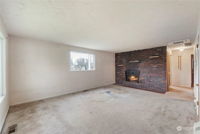 unfurnished living room with light carpet and a brick fireplace