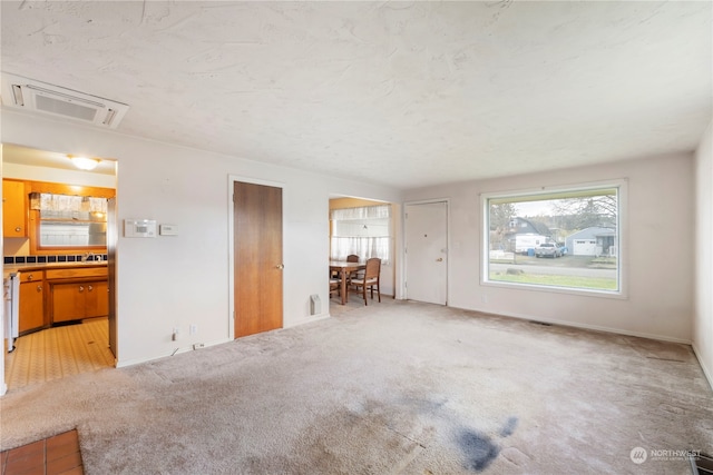 unfurnished living room featuring carpet flooring and sink