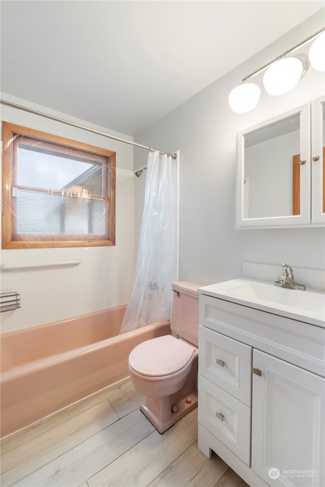 full bathroom with shower / tub combo, vanity, hardwood / wood-style flooring, and toilet