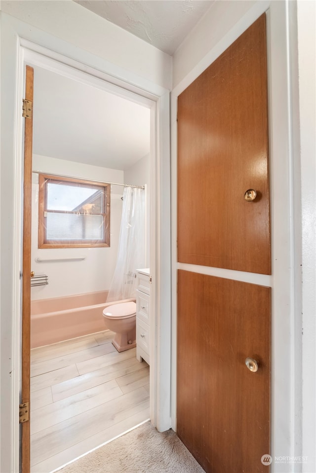 full bathroom featuring hardwood / wood-style floors, vanity, toilet, and shower / bath combo with shower curtain