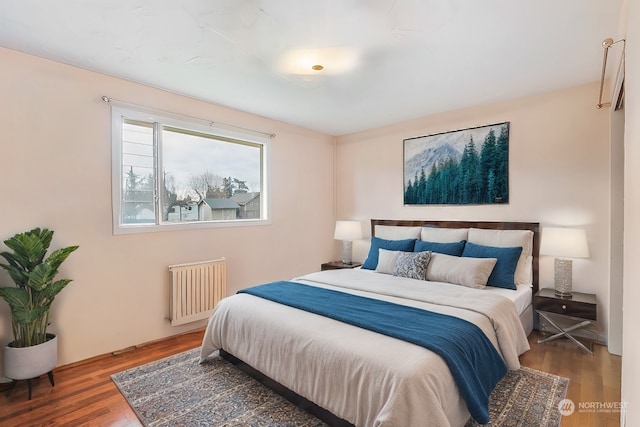 bedroom with hardwood / wood-style flooring and radiator heating unit