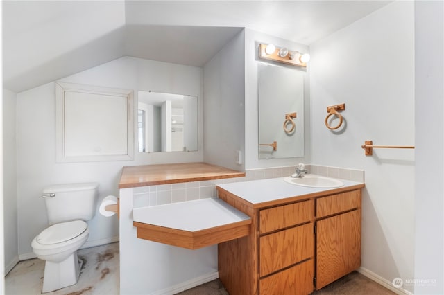 bathroom featuring vanity, toilet, and vaulted ceiling