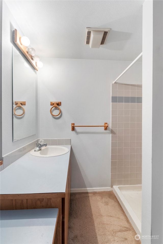 bathroom featuring vanity and a tile shower