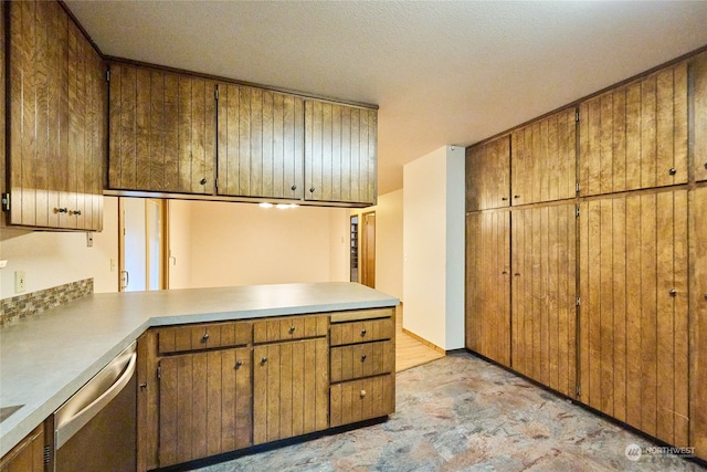 kitchen featuring a textured ceiling and stainless steel dishwasher