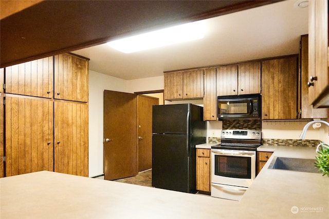 kitchen with decorative backsplash, sink, and black appliances