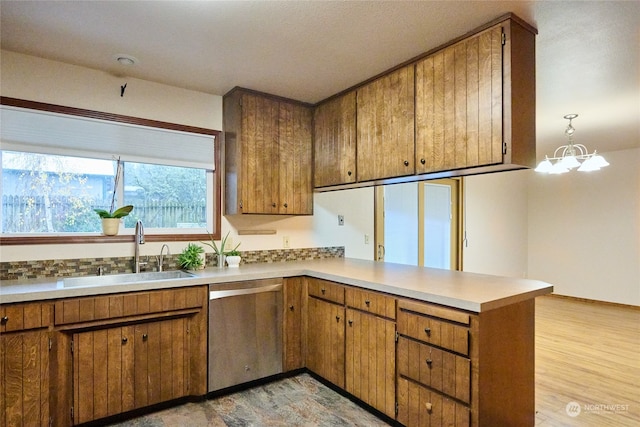 kitchen with kitchen peninsula, sink, light hardwood / wood-style flooring, a notable chandelier, and dishwasher