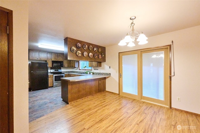 kitchen featuring black appliances, hanging light fixtures, light hardwood / wood-style flooring, kitchen peninsula, and a chandelier