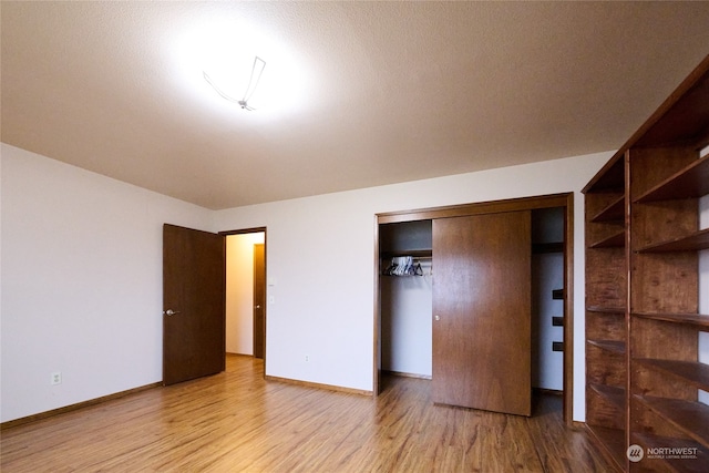 unfurnished bedroom with a closet, light hardwood / wood-style flooring, and a textured ceiling