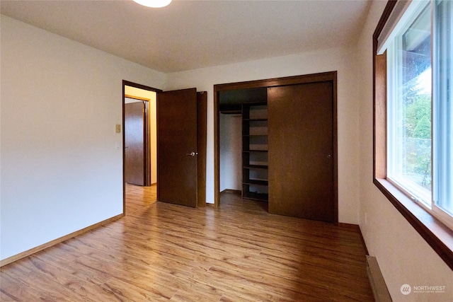 unfurnished bedroom featuring a closet and light wood-type flooring