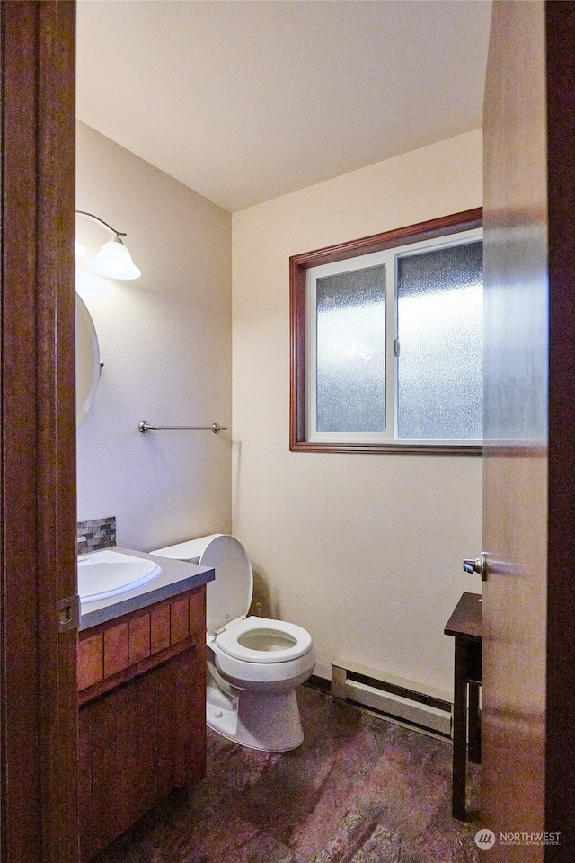 bathroom with vanity, toilet, and a baseboard heating unit