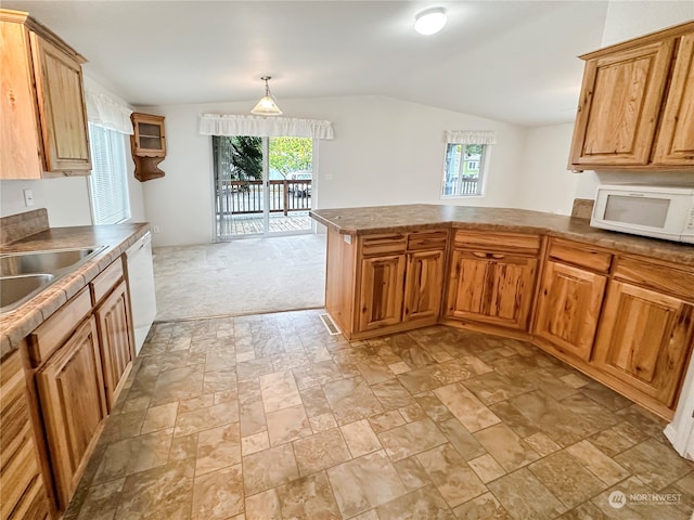 kitchen featuring white appliances, hanging light fixtures, vaulted ceiling, light colored carpet, and kitchen peninsula