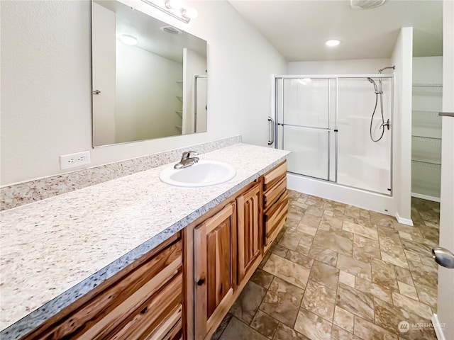 bathroom with vanity and a shower with door