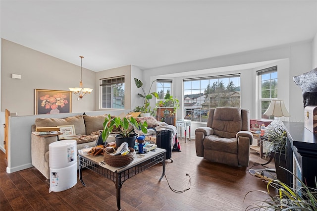 living room with a notable chandelier, dark hardwood / wood-style flooring, and lofted ceiling