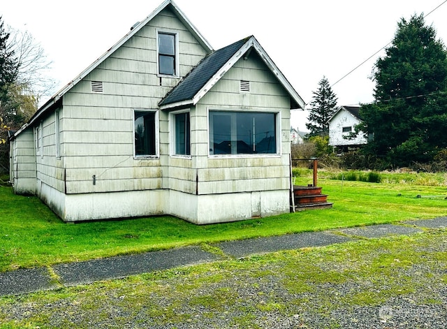 view of side of home with a yard