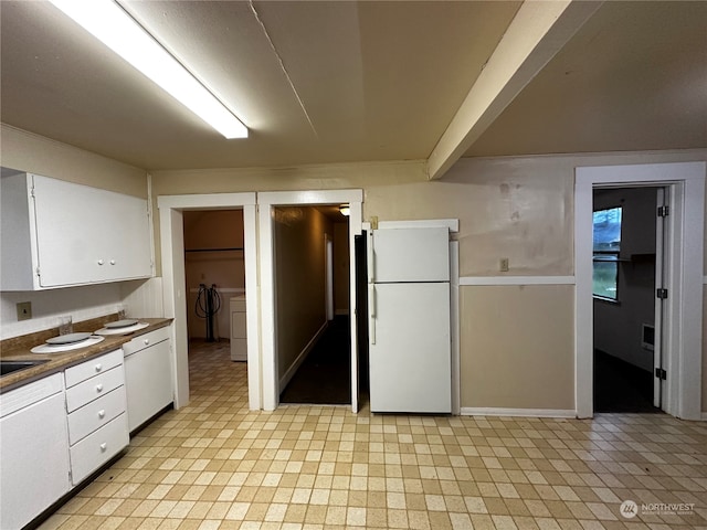 kitchen with white cabinets, white refrigerator, and washing machine and dryer