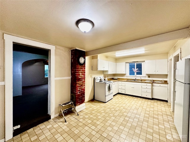 kitchen with white cabinetry, sink, white appliances, and a textured ceiling