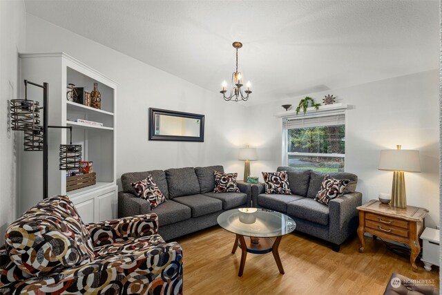 6205 NE Central Valley Rd NE, Bremerton, WA 98311 - living room featuring a chandelier, light wood-style flooring, and vaulted ceiling