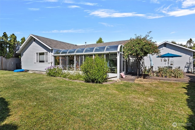 back of house featuring a sunroom and a lawn