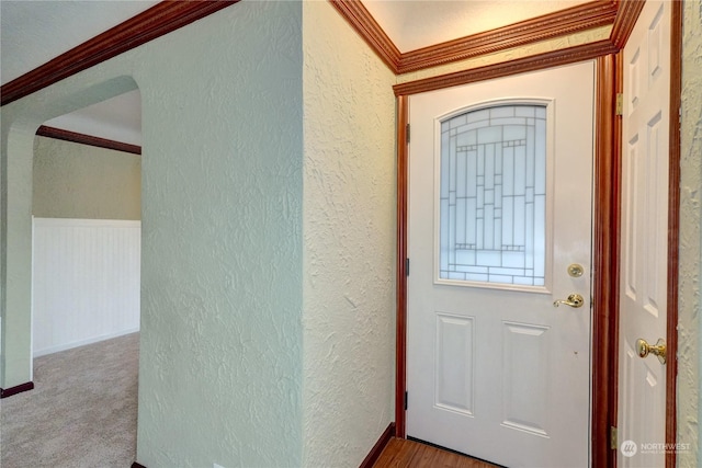 carpeted foyer featuring ornamental molding