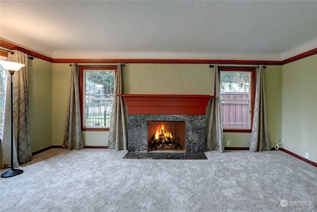 unfurnished living room with a high end fireplace, a textured ceiling, and light colored carpet