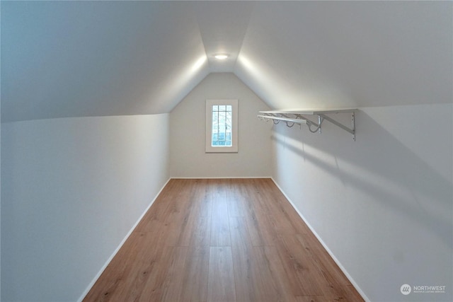 additional living space with lofted ceiling and light wood-type flooring