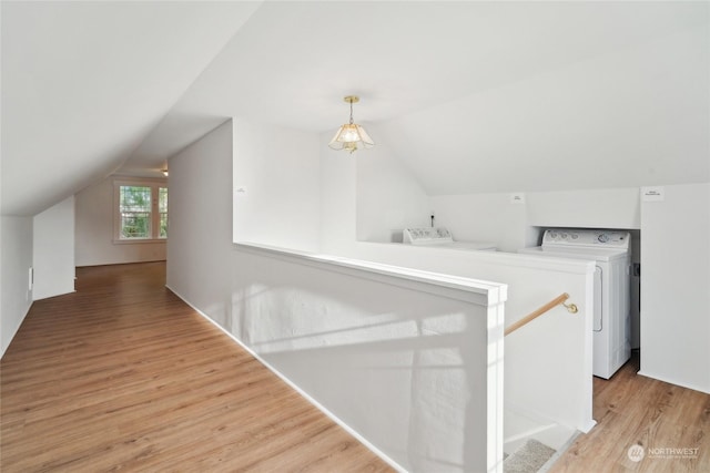 interior space with light hardwood / wood-style floors, vaulted ceiling, and washing machine and clothes dryer