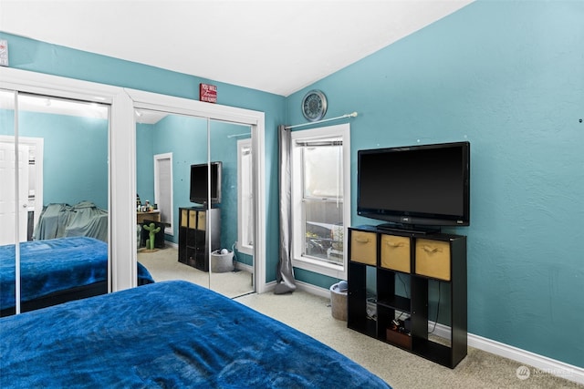 carpeted bedroom featuring a closet and vaulted ceiling