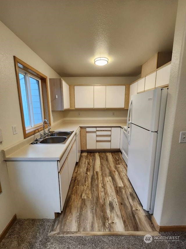 kitchen featuring sink, white cabinets, and white appliances