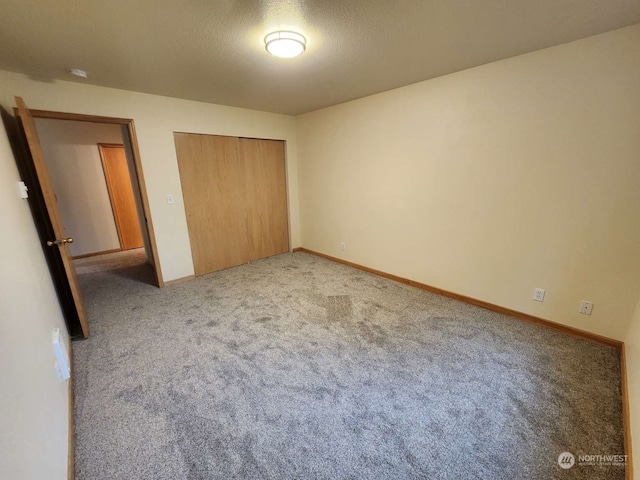 unfurnished bedroom with a closet, light colored carpet, and a textured ceiling