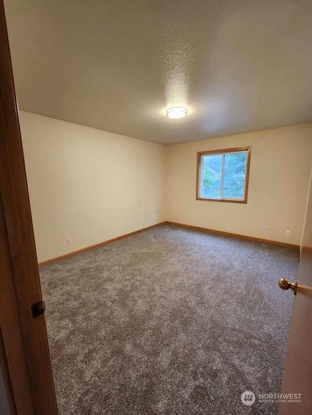 carpeted empty room with a textured ceiling