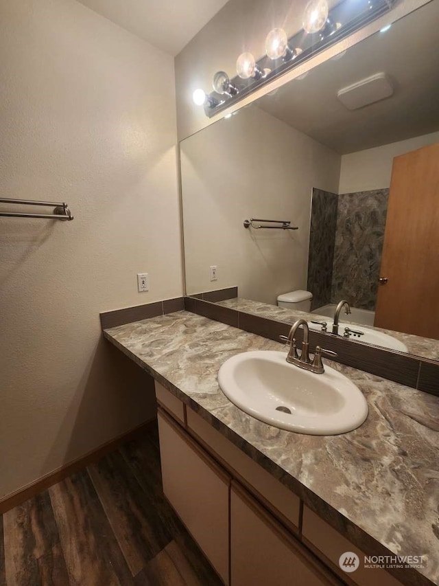 bathroom with hardwood / wood-style flooring, vanity, and toilet