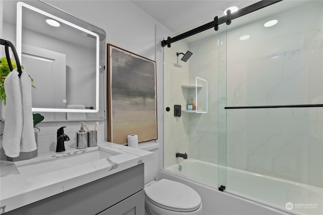 full bathroom featuring vanity, combined bath / shower with glass door, and toilet