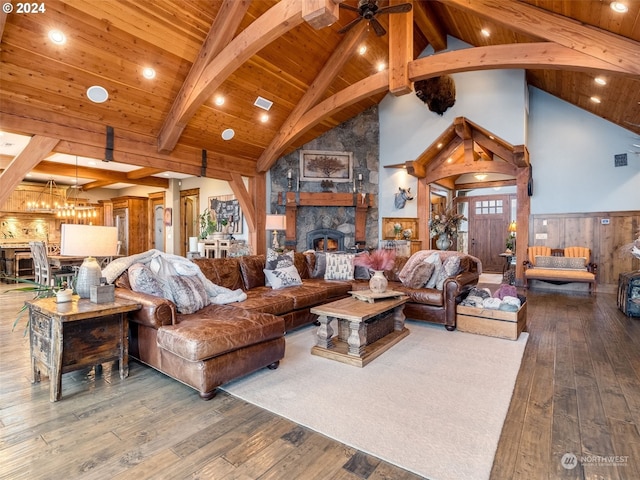 living room with beam ceiling, wooden ceiling, a stone fireplace, high vaulted ceiling, and hardwood / wood-style floors